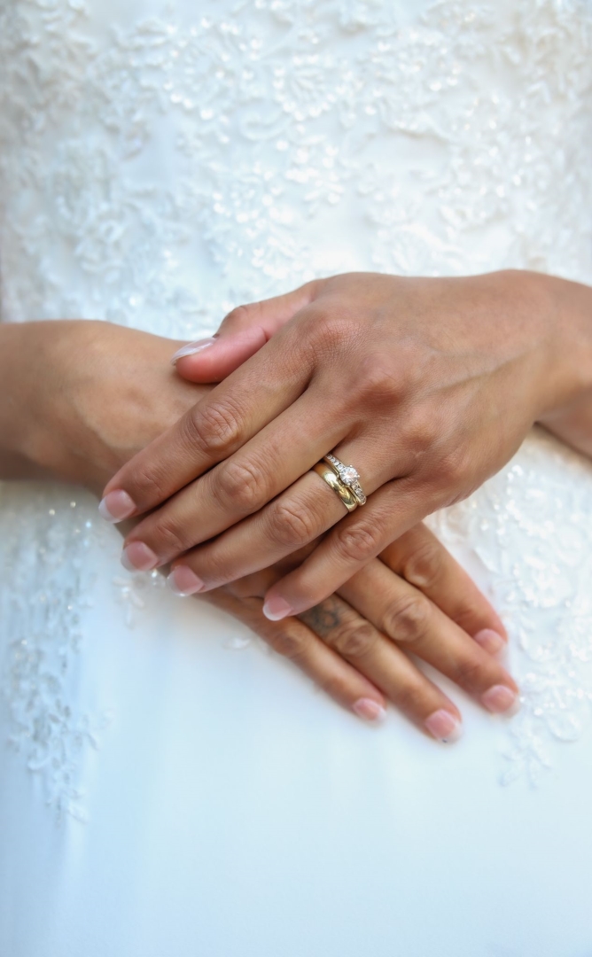 bruiloft handen met ring voor de buik in de trouwjurk